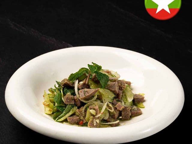 Myanmar-style beef salad with sliced onion, mint and chili in a white bowl at Burbrit Myanmar