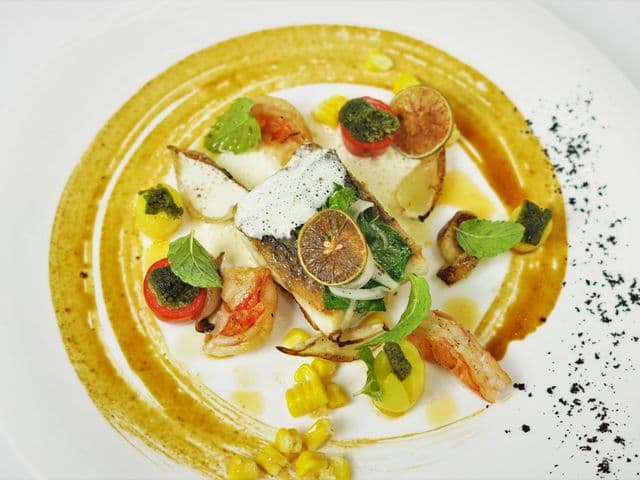 SEEDS Restaurant & Loungeの魚のソテー、海老・コーン・焼きライム・ハーブ添え、琥珀色のソースの渦